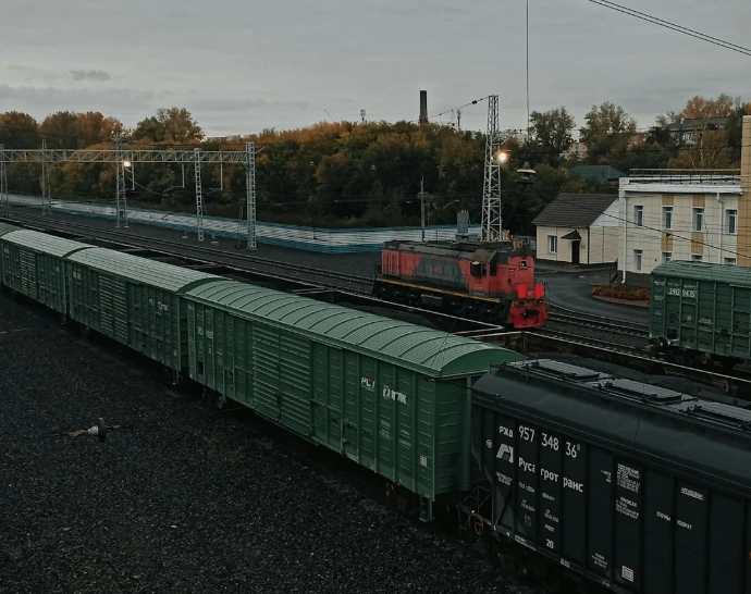a train traveling down train tracks next to a tall building